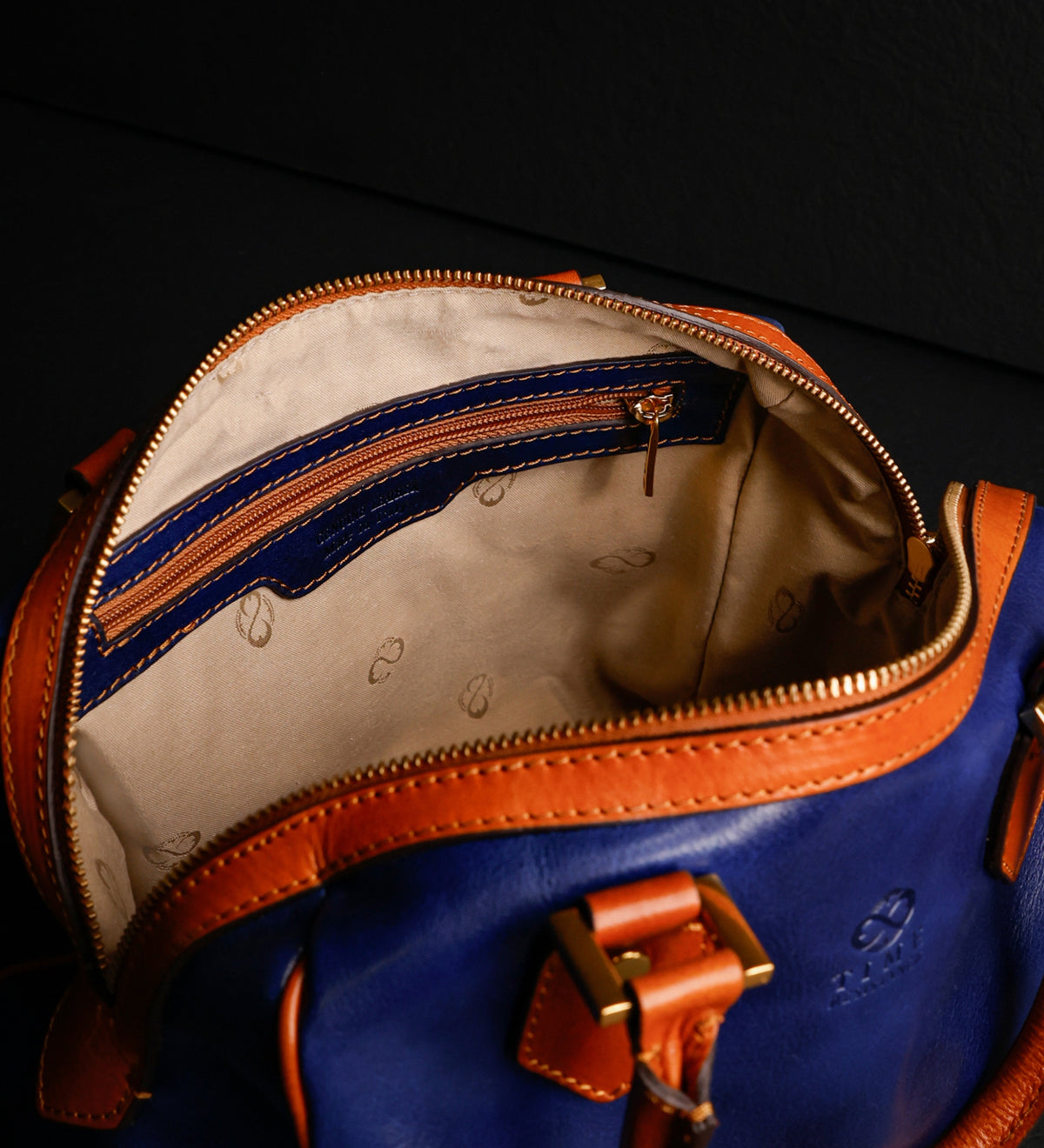 Bauletto Little Dorrit blu aperto su sfondo scuro, con la fodera color crema visibile all'interno