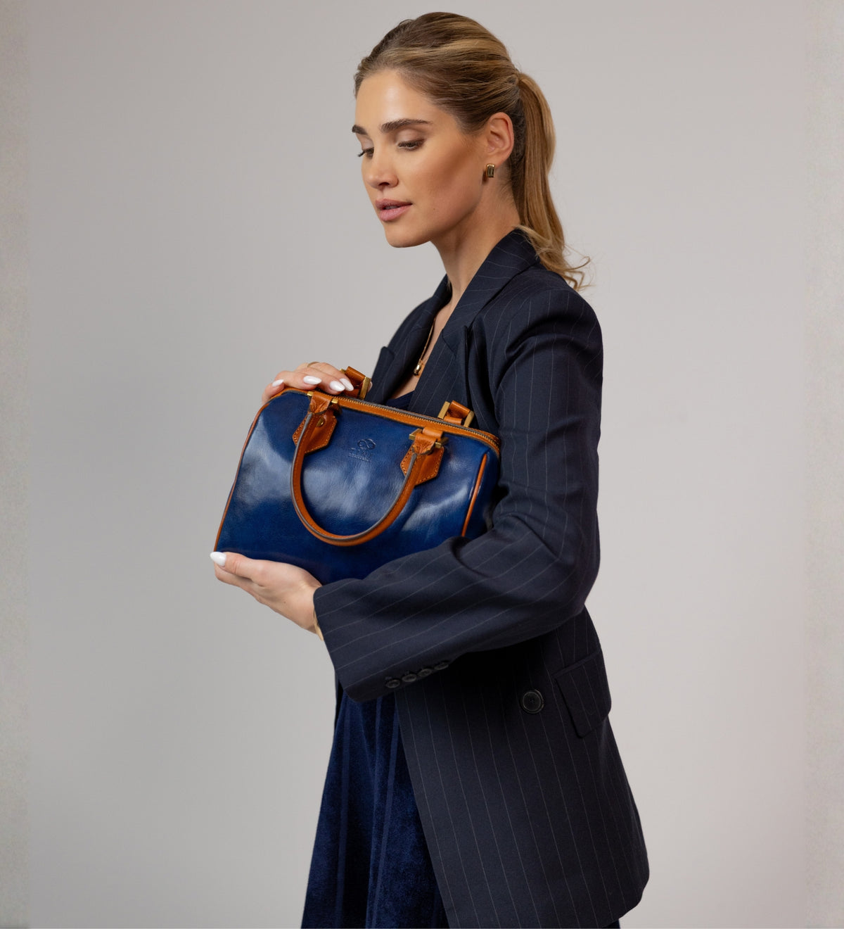 Donna che culla il bauletto Little Dorrit blu con entrambe le mani